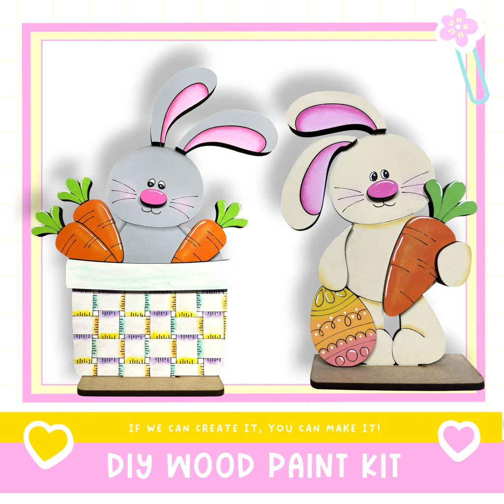 two wooden Easter bunny decorations, one holding a carrot and the other holding an Easter egg, set against a pink and yellow background.