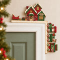 A decorative Christmas-themed house is mounted on the wall above a door, with a small Santa Claus figurine sitting on the door.