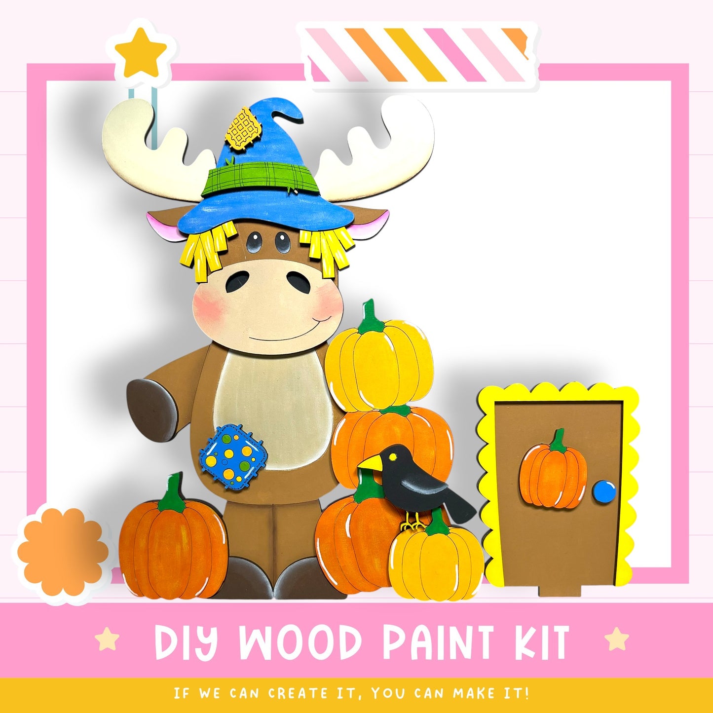 A wooden toy moose wearing a witch's hat and surrounded by carved pumpkins, with a sign that says "DIY WOOD PAINT KIT" and a message encouraging creativity.