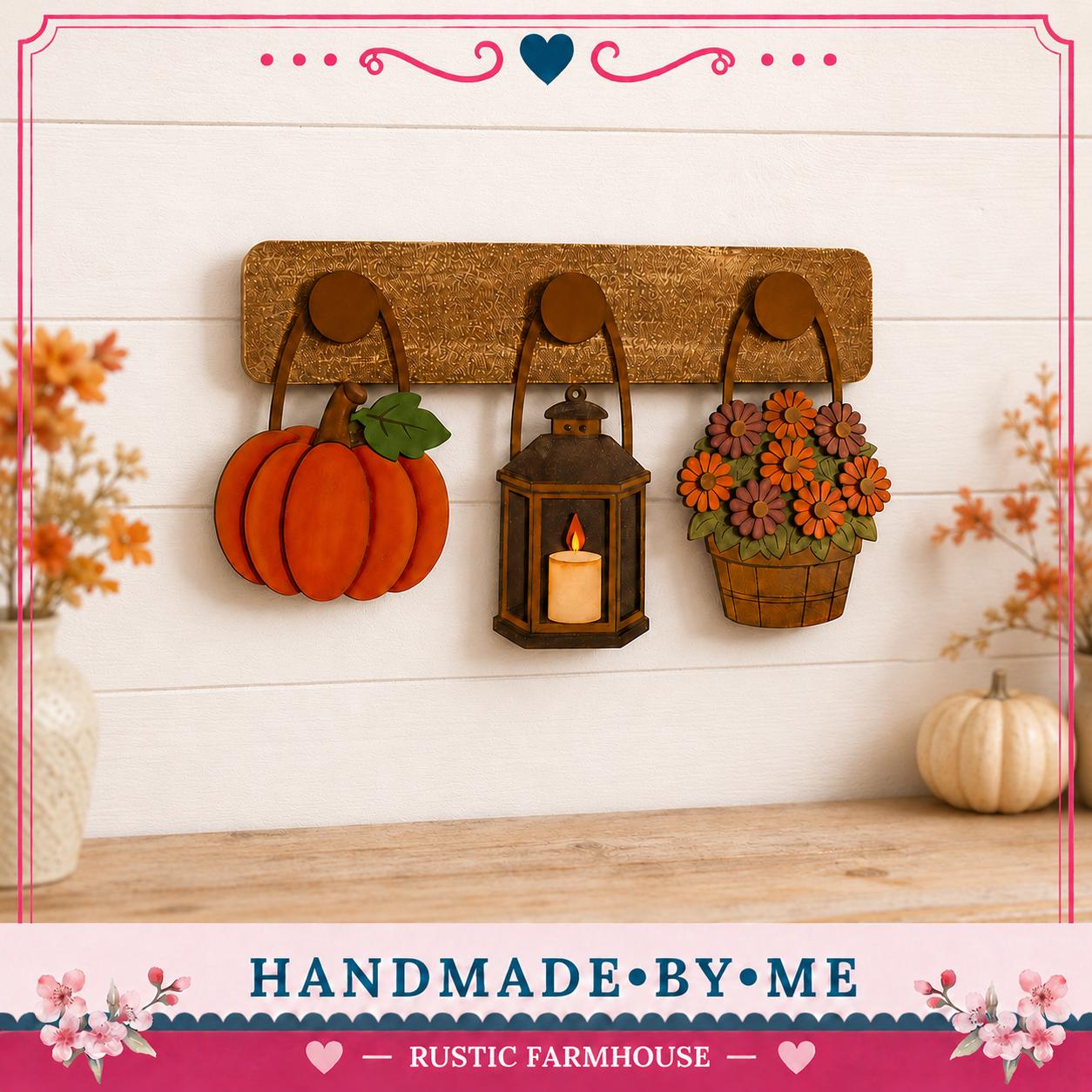 a rustic farmhouse-style decoration with a wooden shelf holding three handcrafted items: a pumpkin lantern, a basket of flowers, and a white pumpkin. The items are displayed on a white wall, creating a cozy and autumnal atmosphere.