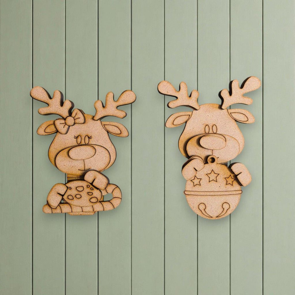 two wooden reindeer or antlers hanging on a green wooden wall.