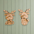 two wooden reindeer or antlers hanging on a green wooden wall.