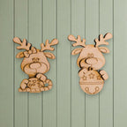 two wooden reindeer or antlers hanging on a green wooden wall.