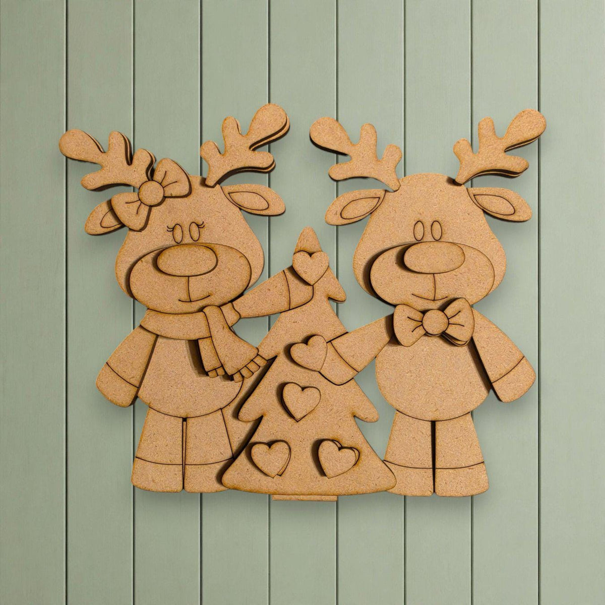 A wooden cutout of two cartoon reindeer standing next to a Christmas tree, with hearts on the tree.
