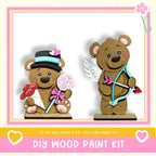 two wooden teddy bears, one holding a bouquet of flowers and the other holding a bow and arrow, set against a pink and white background.