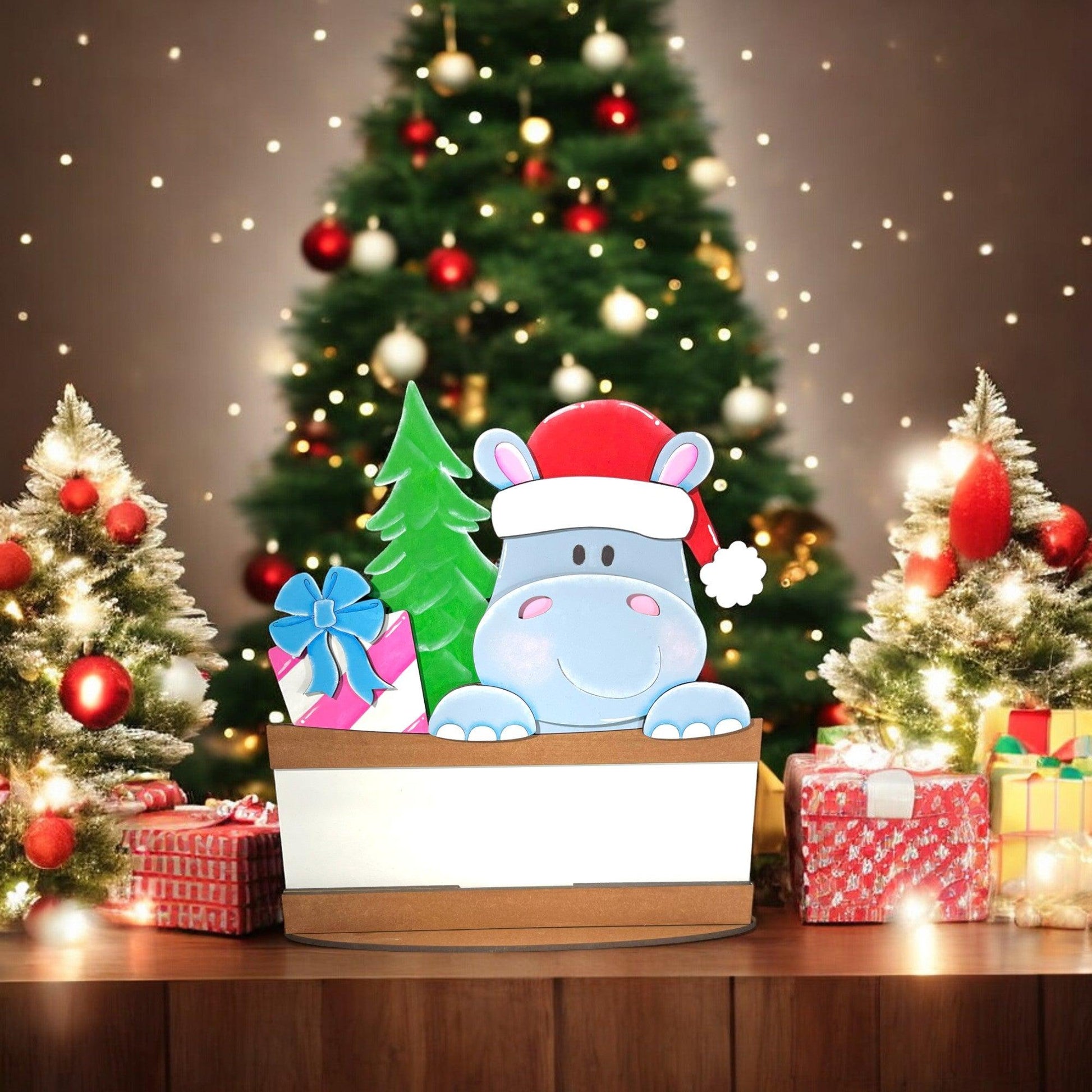 a christmas tree with presents and a hippo in a box