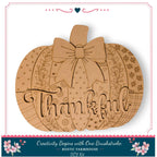 A wooden pumpkin with the word "Thankful" written on it, decorated with various patterns and designs.