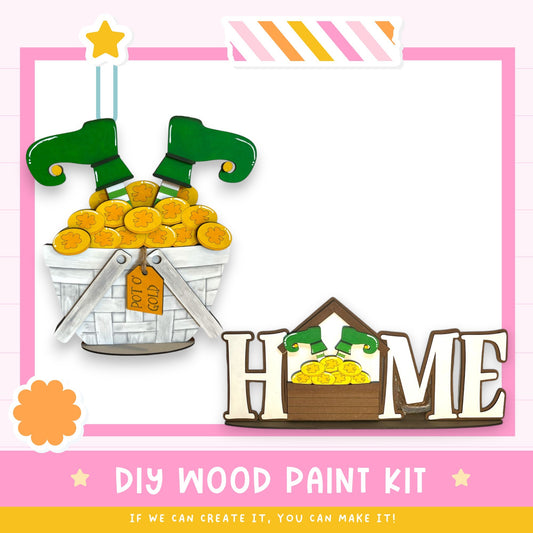 The image is a DIY wood paint kit for creating a wooden sign that says "HOME". The kit includes a wooden sign, a pair of green elf boots, and a basket filled with gold coins. The kit is designed to be a fun and creative project for anyone interested in woodworking and painting.