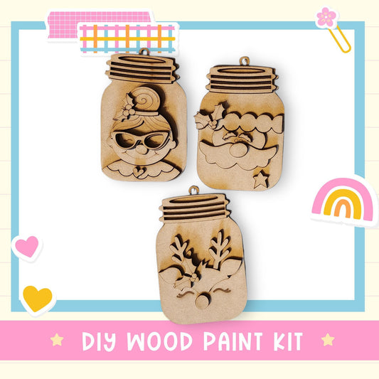 three wooden mason jars with various designs carved into them, including a face, a flower, and a star. The jars are displayed against a light blue background with a pink border.