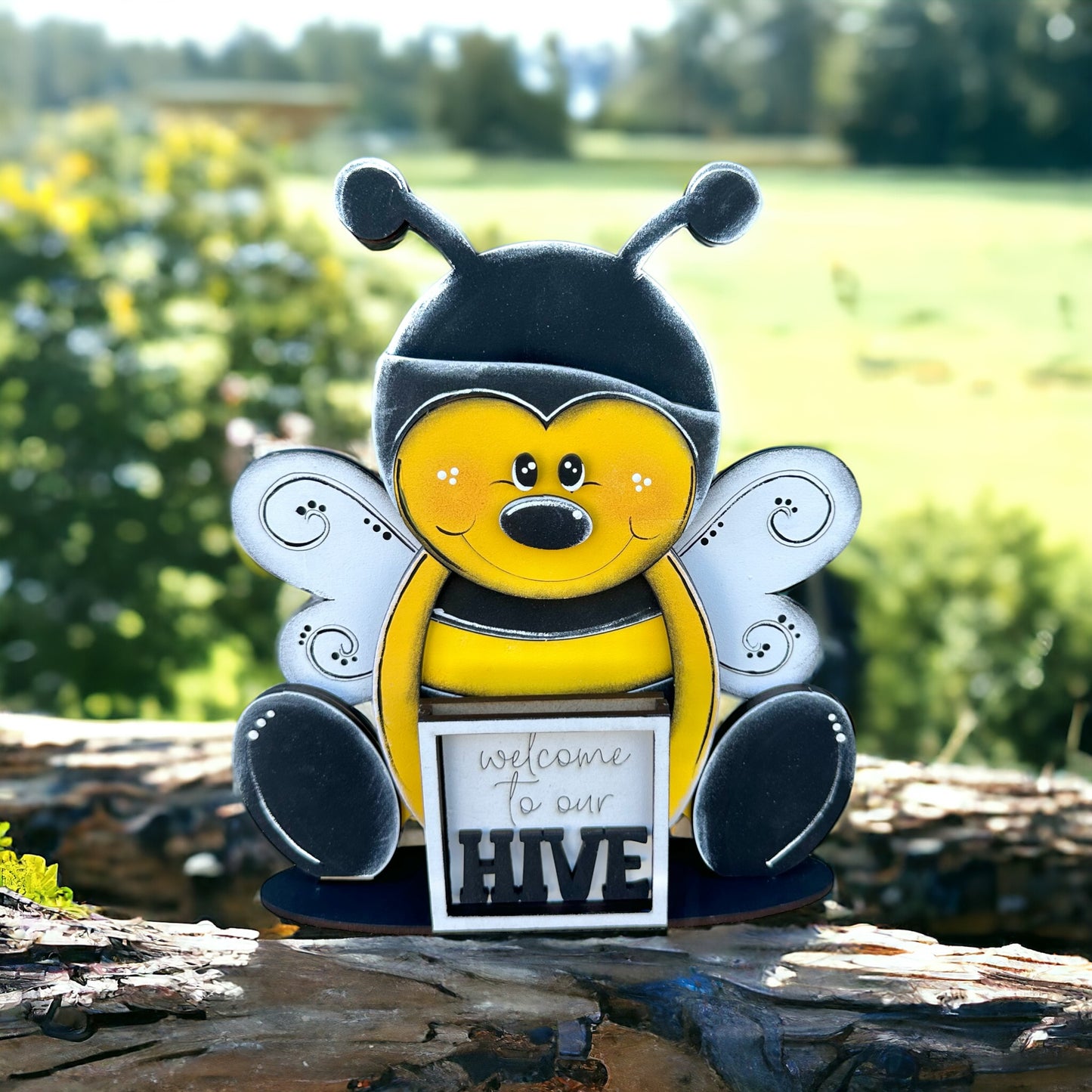 a yellow and black bee figurine with a sign that says welcome to our