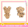 two wooden animal figures, a bunny and a bear, with a pink and white border. The text below the image reads "DIY WOOD PAINT KIT" and "If we can create it, you can make it!"