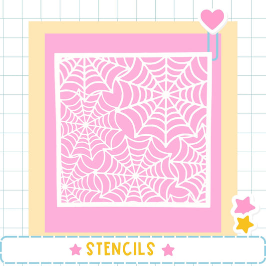 a large square with a pink spider web pattern on it, surrounded by a yellow border. The image is framed by a pink border and includes a heart and two stars as decorative elements. The word "STENCILS" is written in the bottom right corner of the image.