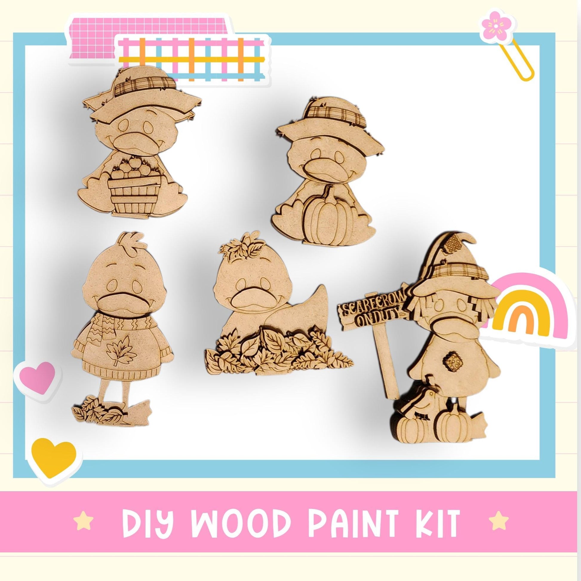 The image is a DIY wood paint kit featuring various wooden characters, including a duck, a pumpkin, and a sign, along with some decorative elements such as hearts and a rainbow.