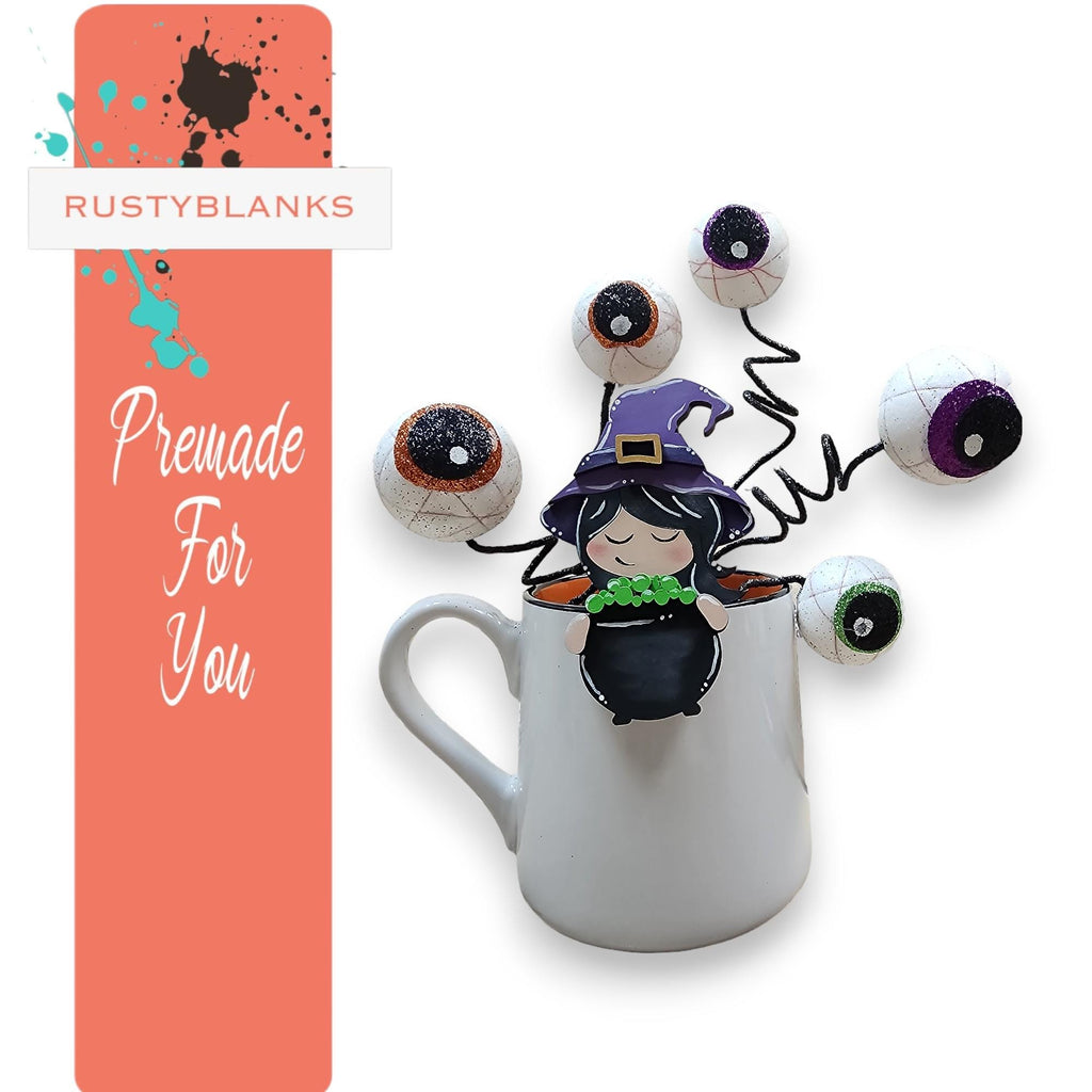 a coffee mug with a halloween decoration in it