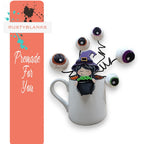 a coffee mug with a halloween decoration in it