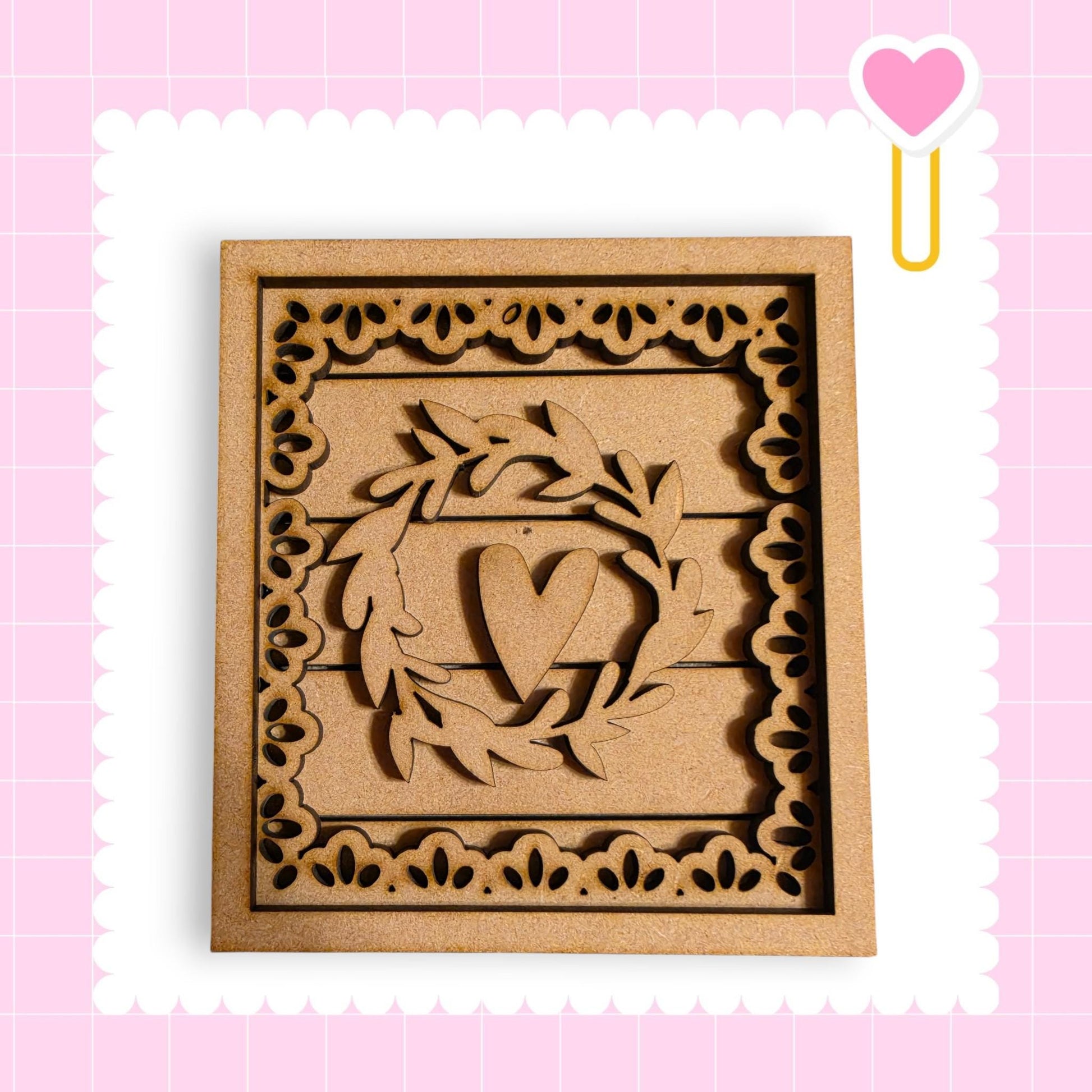 a wooden frame with a heart-shaped cutout in the center, surrounded by a decorative border.