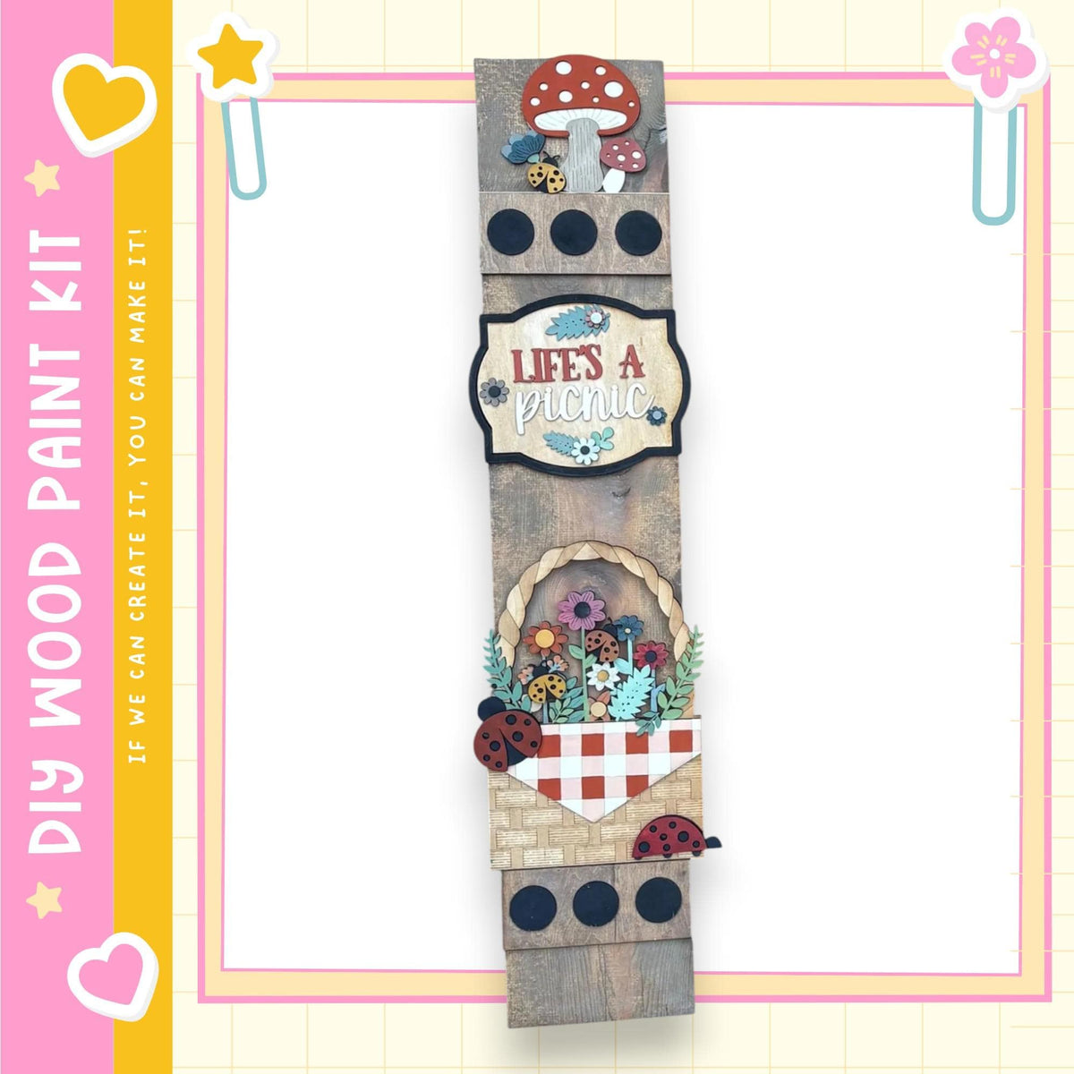 The image is a wooden sign with various decorative elements, including a mushroom, flowers, and ladybugs, mounted on a wooden frame.