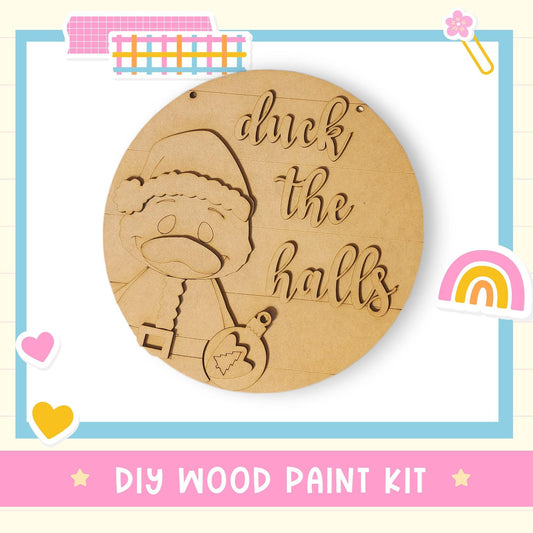 a DIY wood paint kit with a wooden sign that says "chuck the halls" and a wooden Santa Claus figure.