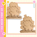 two wooden cutouts of sheep, each with a flower attached to its head. The sheep are positioned on a grassy surface, creating a charming and whimsical scene.