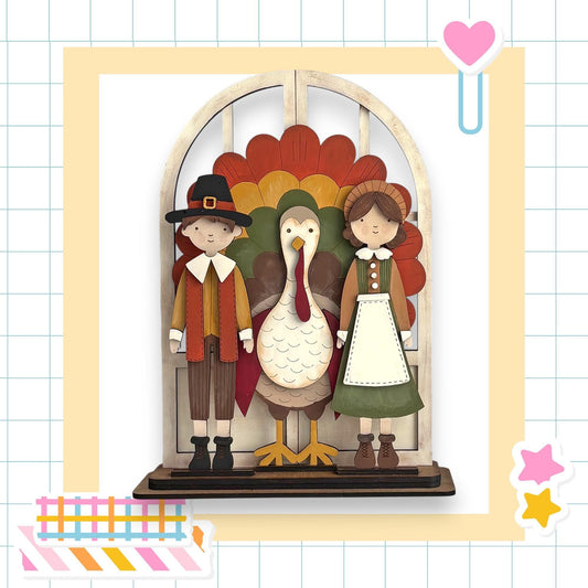 A wooden display featuring a turkey, a boy in a hat, and a girl in a dress, all standing together.