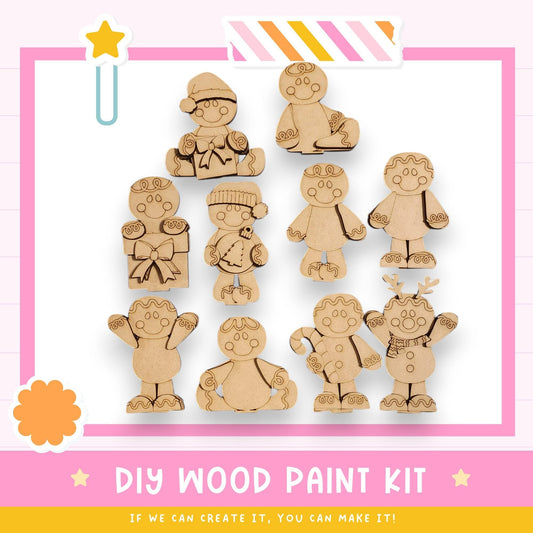 a DIY wood paint kit with various wooden figures, including gingerbread men, on a pink background.