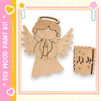 A wooden angel figure holding a candle and a musical note-shaped ornament, both of which appear to be part of a DIY paint kit.