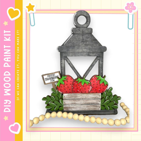 A wooden lantern with a sign that reads "Fresh Strawberries" is displayed against a white background, surrounded by a beaded garland.