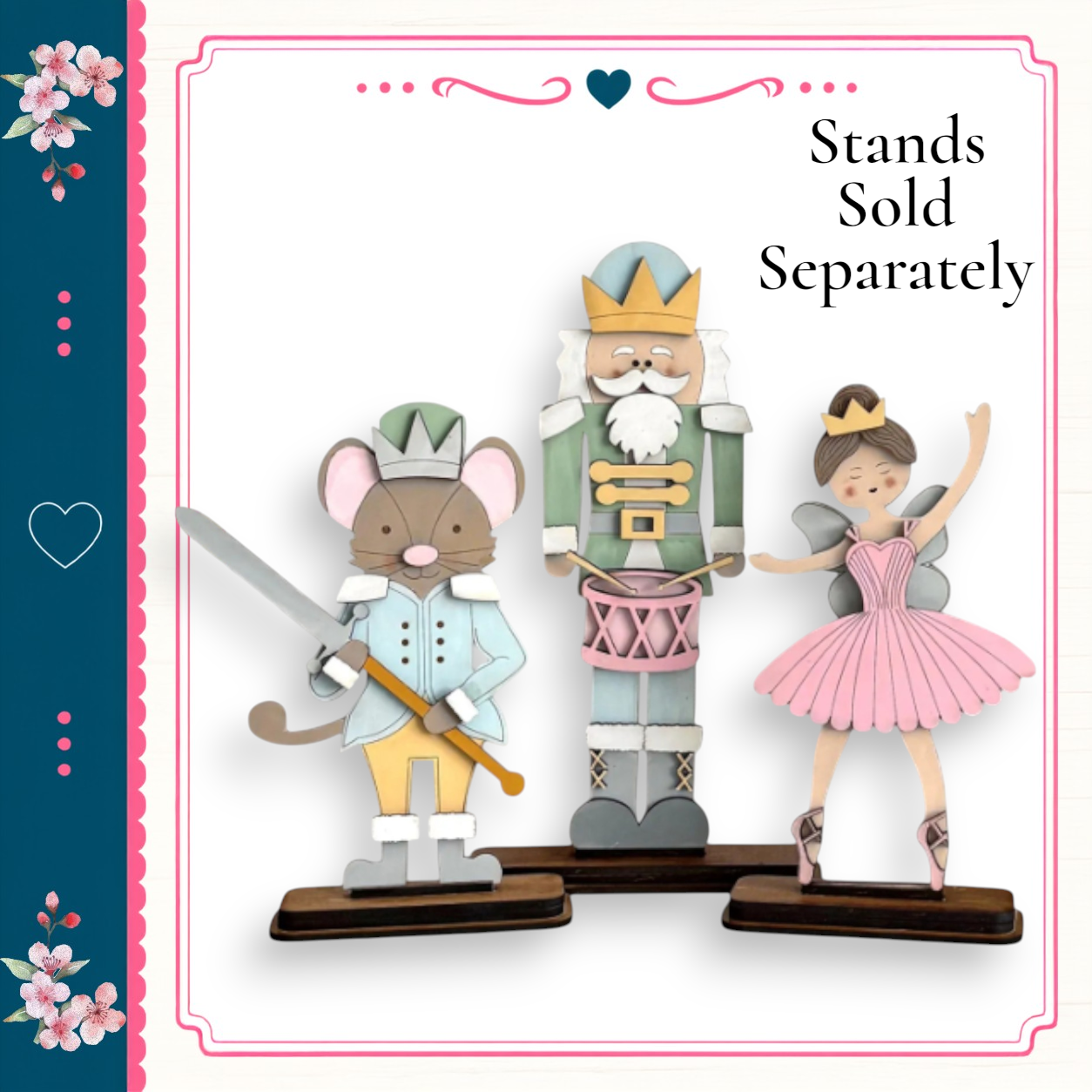A wooden nutcracker figure holding a sword and a mouse figure, with a ballerina figure in a pink tutu, all standing on a wooden base.