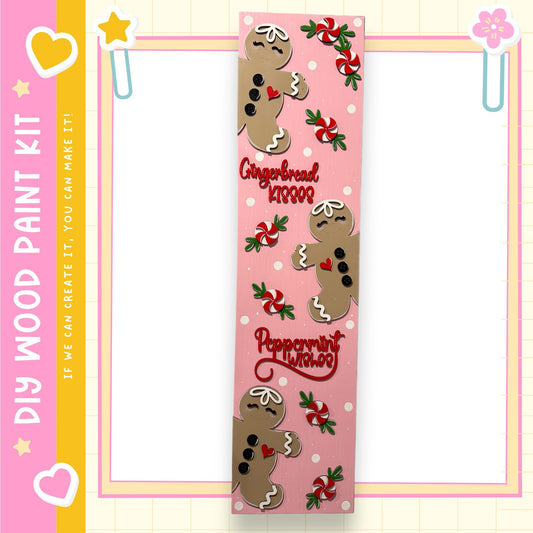 A pink and yellow frame with a decorative border, featuring a large gingerbread man and peppermint candies.