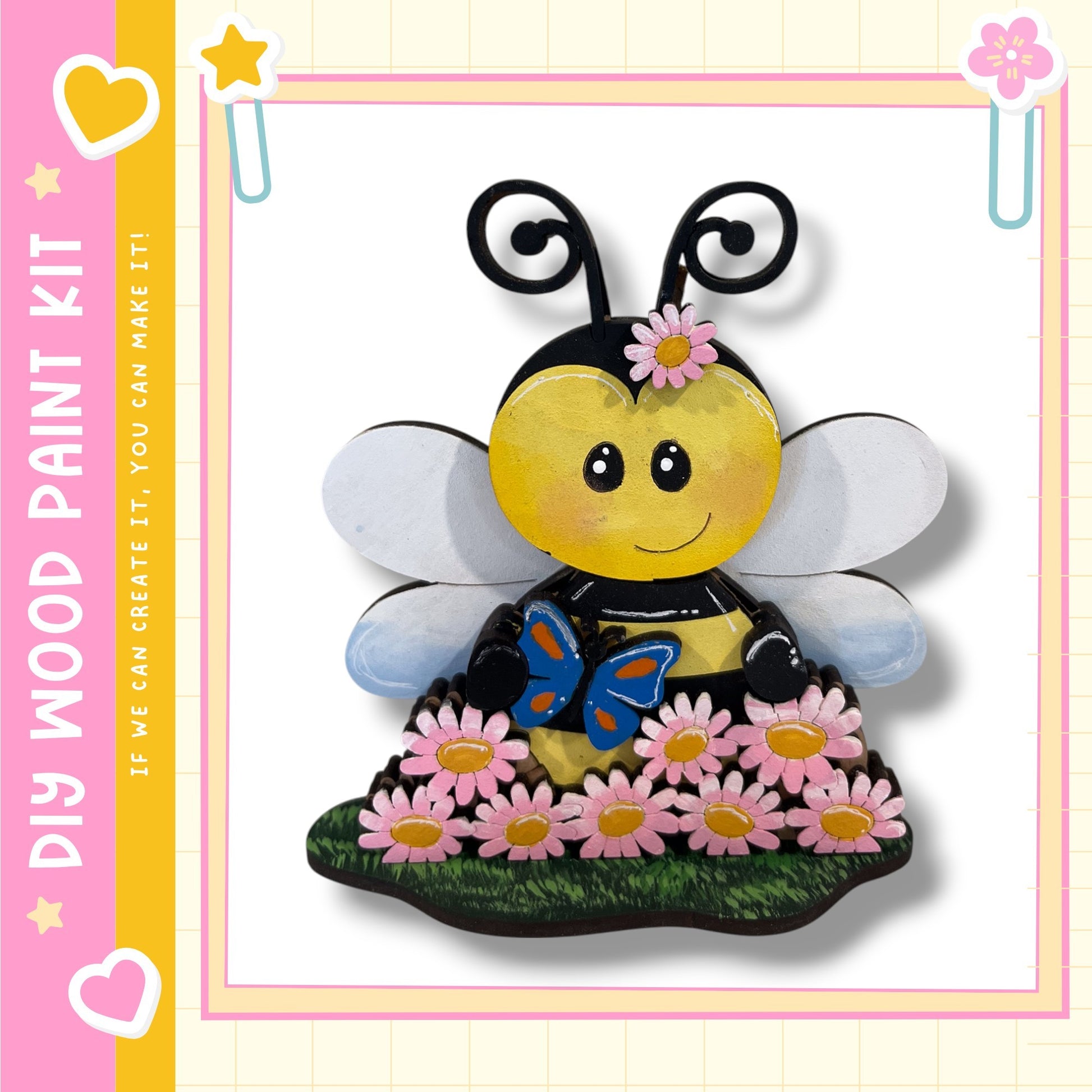 A cheerful painted bee with a flower on its head, surrounded by pink flowers, is depicted in the image.