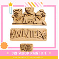 The image is a promotional poster for a DIY wood paint kit for creating winter-themed decorations. It features three wooden snowmen and a snowman-shaped sign with the word "WINTER" written on it.