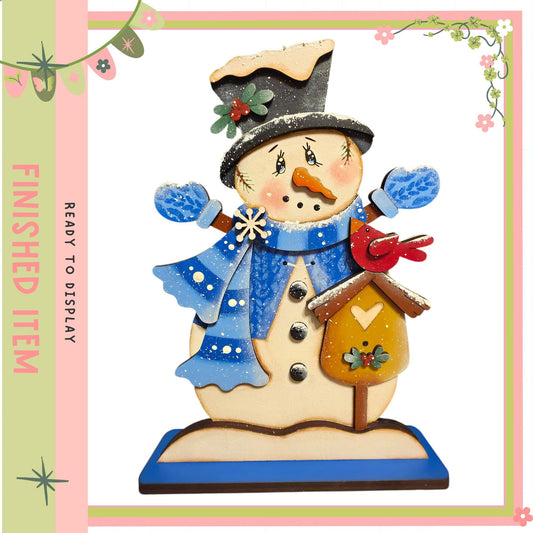 A snowman figurine with a bird perched on its shoulder, wearing a blue scarf and hat, and holding a birdhouse.