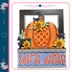 A decorative pumpkin with sunflowers and birds, accompanied by the text "Sweater Weather" in a colorful frame.