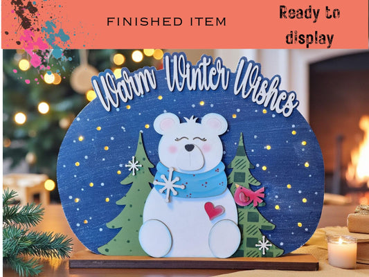 A wooden sign with a polar bear and winter-themed decorations, including snowflakes and a heart, is displayed in front of a fireplace.
