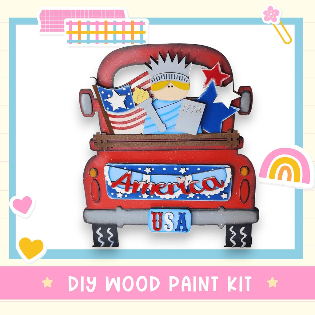 The image is a colorful and playful depiction of a red truck with a wooden figure of a woman holding an American flag and a star, surrounded by various decorative elements such as hearts, stars, and a rainbow.