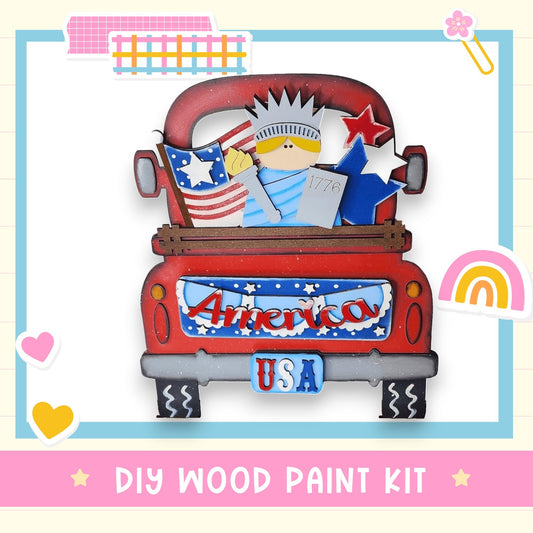 The image is a colorful and playful depiction of a red truck with a wooden figure of a woman holding an American flag and a star, surrounded by various decorative elements such as hearts, stars, and a rainbow.
