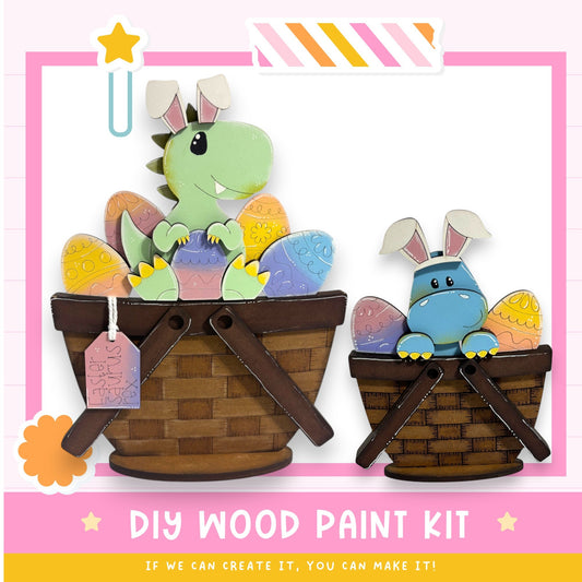two wooden baskets filled with colorful Easter eggs, each containing a small toy dinosaur. The baskets are placed against a pink and white background, and there is a text box at the bottom of the image that reads "DIY WOOD PAINT KIT" and "If we can create it, you can make it!"