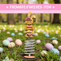 A whimsical Easter-themed scene featuring a toy rabbit on a spring-like structure, surrounded by colorful Easter eggs in a grassy field.