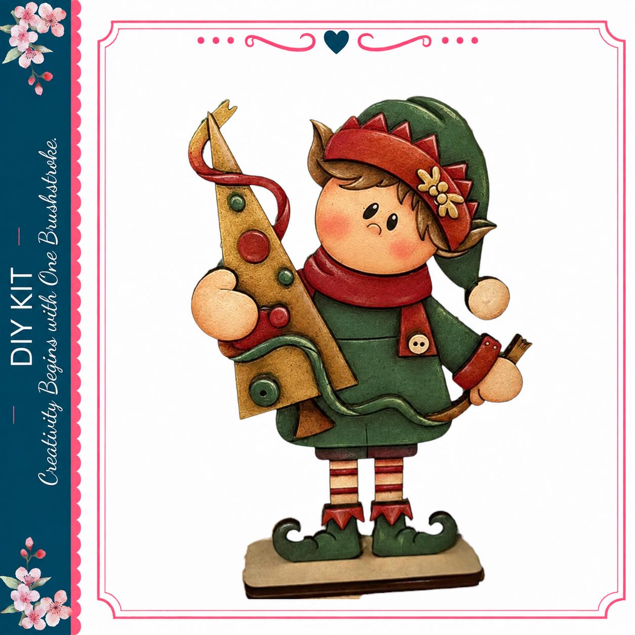A wooden elf figurine holding a Christmas tree, wearing a green outfit with red and gold accents.