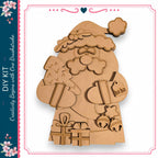 The image is a cardboard cutout of a Santa Claus figure, with various holiday-themed elements such as a Christmas tree, presents, and bells.