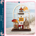 A wooden lighthouse with a castle, beach chair, and umbrella, set against a blue background with a white border.