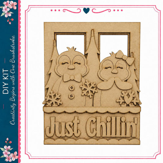 A wooden frame with two cartoon penguins and snowflakes, along with the text "Just Chilling" on it.