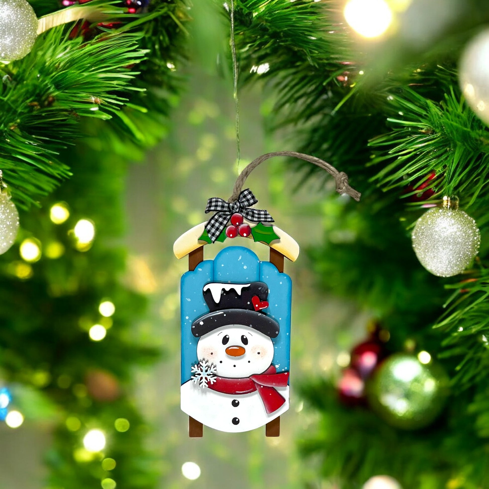 a snowman ornament hanging from a christmas tree