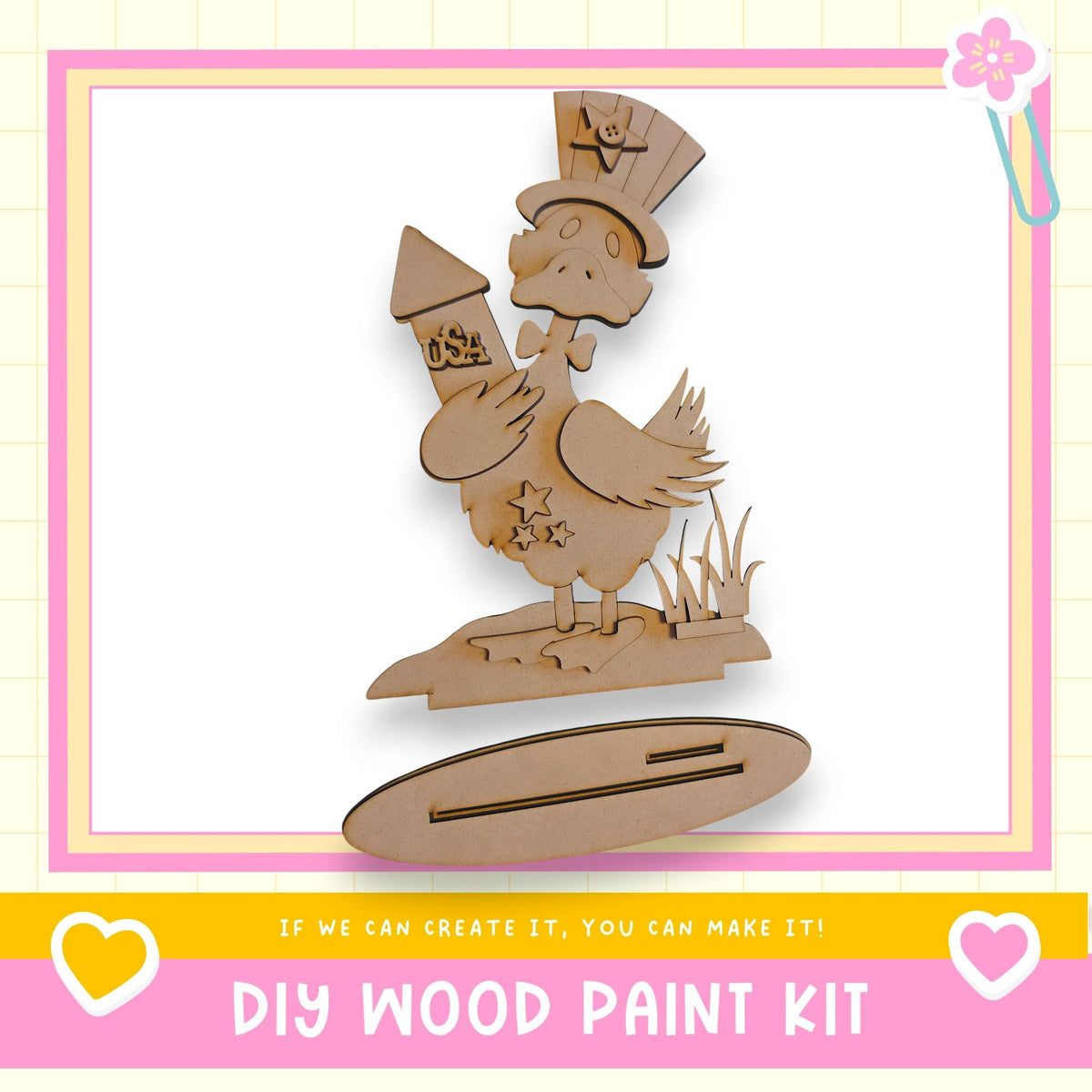 a DIY wood paint kit, with a wooden duck holding a rocket ship and a star on its back, set against a pink and yellow background.
