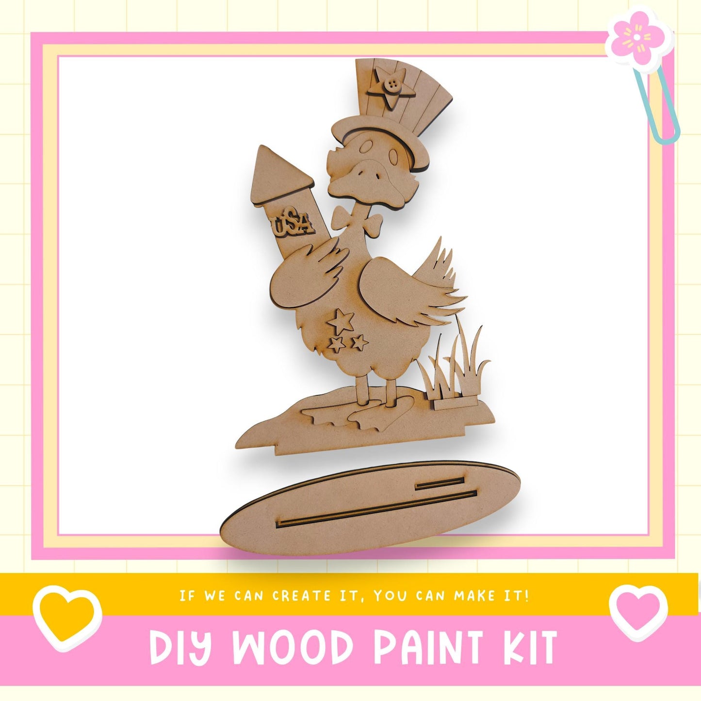 a DIY wood paint kit, with a wooden duck holding a rocket ship and a star on its back, set against a pink and yellow background.