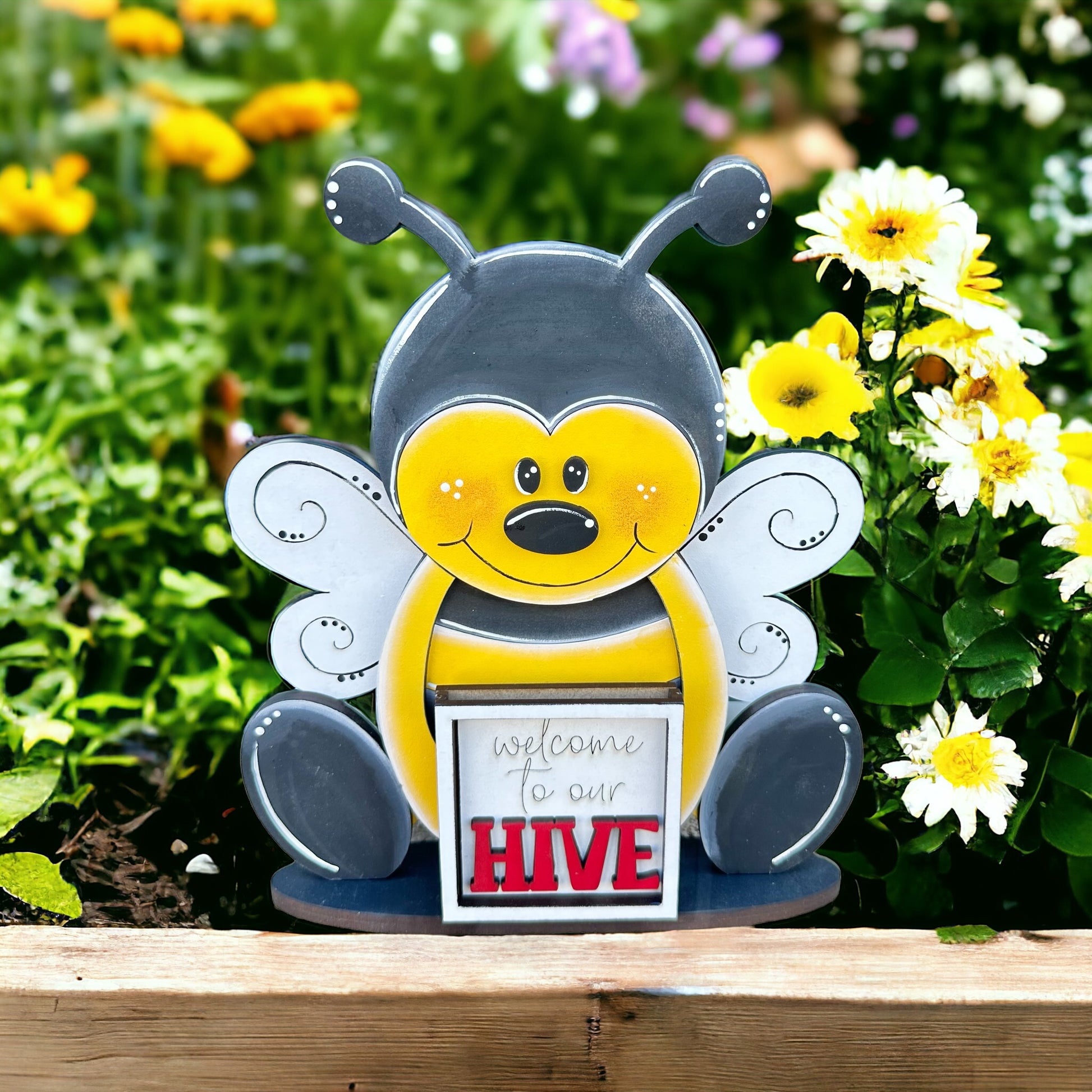 a statue of a bee holding a sign that says, welcome to our hive