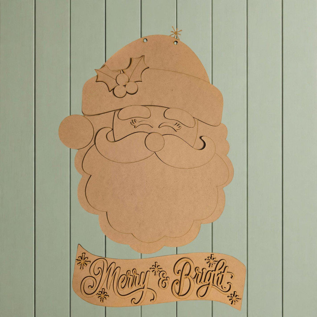 A cardboard cutout of Santa Claus with a holly leaf on his hat, and a banner with the text "Merry & Bright" below it.