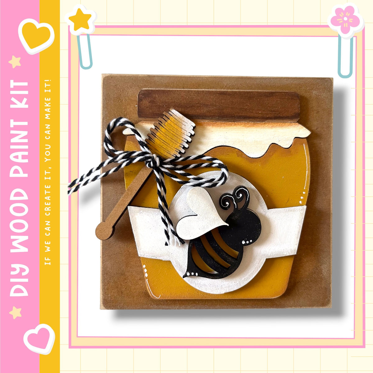 The image is a wooden paint kit featuring a honey jar, a wooden brush, and a black and white bee cutout.