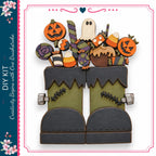 a pair of green monster boots with Halloween-themed decorations, including a jack-o-lantern, a ghost, and candy corn.