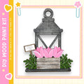 A wooden lantern with pink tulips in a wooden planter box, set against a white background with a pink and yellow border.